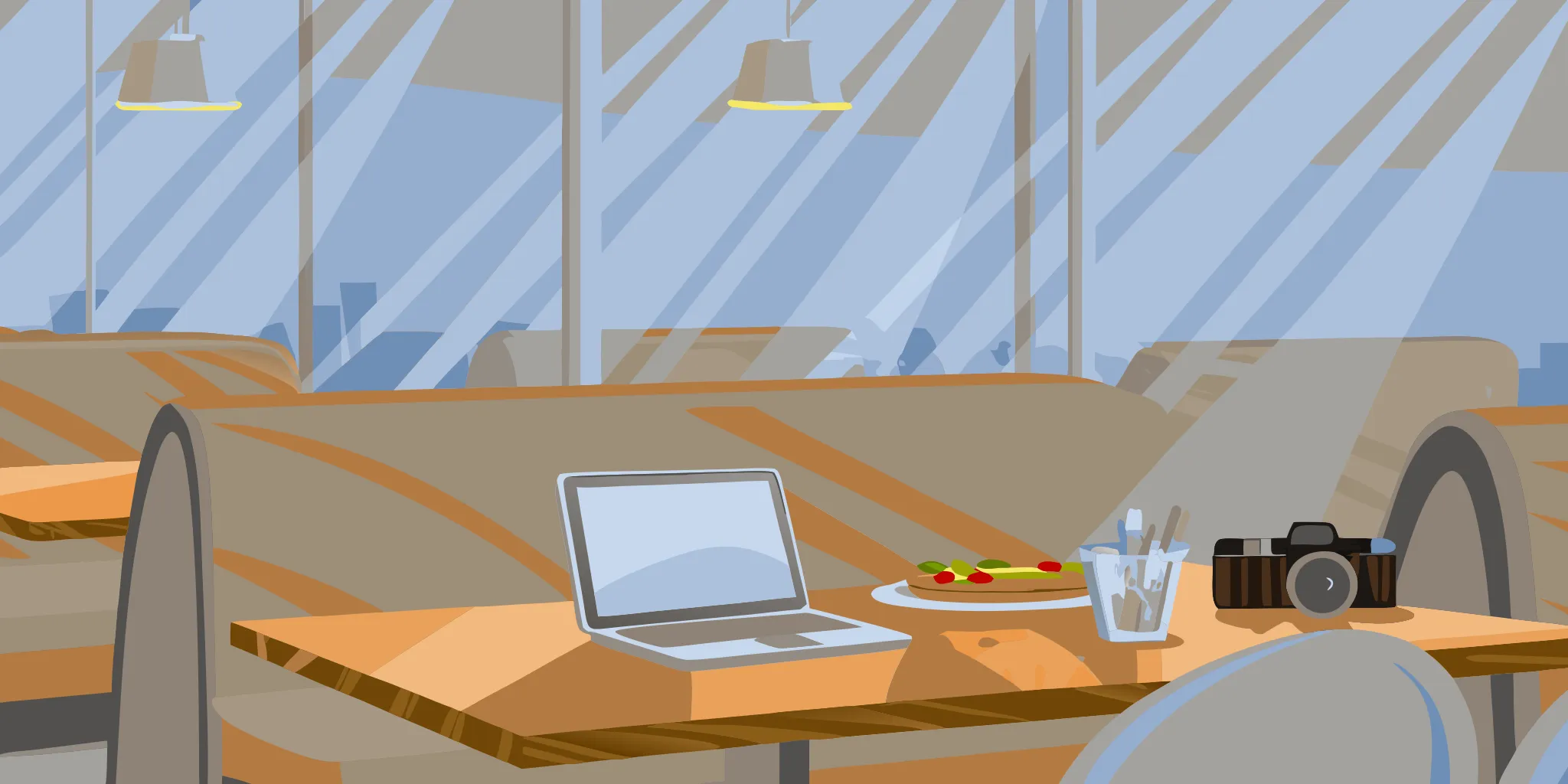 A laptop and camera on a restaurant table for planning local advertising ideas.